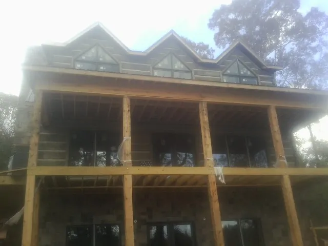 Dormers and porch framing on a large log home under construction — Roof Coating work by our crew in Cockeysville